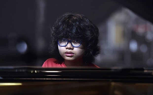 12-year-old Indonesian jazz pianist Joey Alexander sits at the piano on the main stage of the "Jazz in Marciac" festival prior to his perfomance on August 10, 2015 in Marciac, southwestern France. AFP PHOTO/PASCAL PAVANI 
