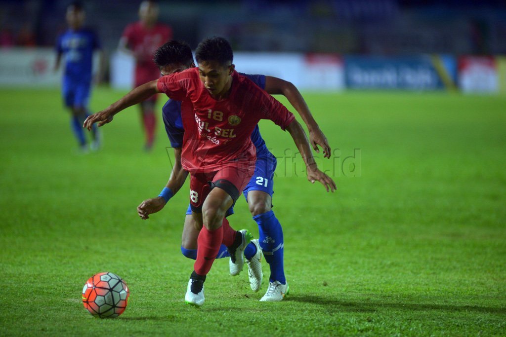 Pesepak bola Jabar berebut bola dengan pesepak bola Sulsel  pada laga final PON XIX di Stadion Si Jalak Harupat, Kabupaten Bandung, Jawa Barat, Rabu (28/9). Jabar menyabet medali emas setelah menang adu pinalti dengan skor 5-4. Wartakita/Iqbal Lubis