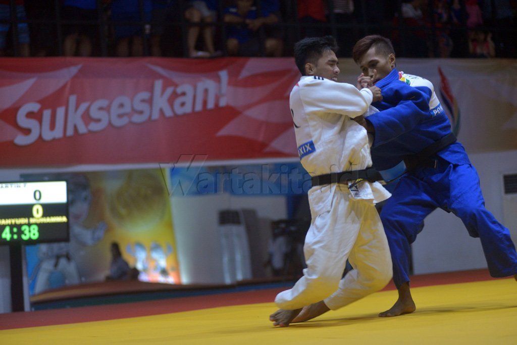 Judoka putra Sulsel Aditya Wahyudi Muhammad (biru) saling mengunci dengan lawannya judoka Jabar Fendi Martin (putih) pada final Judo Putra kelas -60 kg PON XIX Jabar di Arena Saparua Sport Park, Bandung, Sabtu (17/9). Aditya Wahyudi Muhammad berhasil meraih medali emas, sementara medali perak diraih judoka Jabar Fendi Martin dan perunggu direbut judoka Jabar Hendi Hadiat serta judoka DKI Jakarta Budi Prasetyo. Wartakita/Iqbal Lubis