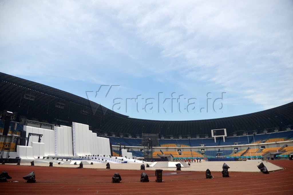 Pekerja menyelesaikan pembangunan  kirab Api PON XIX di Stadion Glora Bandung Lautan Api (GLBA) di Bandung, Jawa Barat, 16 September 2016. Panitia Besar (PB) Pekan Olahraga Nasional (PON) XIX/2016 di Jawa Barat mengalokasikan tiket gratis untuk umum yang ingin menyaksikan secara langsung upacara pembukaan di GLBA. Wartakita/IqbaL Lubis