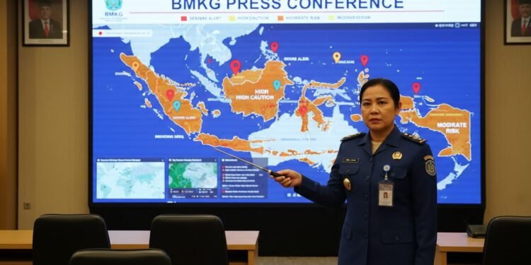 Peringatan Dini Cuaca BMKG 9-10 Oktober 2026, Ini Daftar Wilayah Terdampak Seorang meteorologis BMKG sedang memberikan presentasi tentang peringatan dini cuaca di sebuah konferensi pers. Peta di depannya menunjukkan wilayah-wilayah yang terdampak dengan tanda-tanda berbeda,