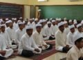 Sejumlah pegawai dari Bapas Makassar sedang menghadiri kajian rutin 'Bersih Sebelum Beribadah' di ruang kelas yang modern. Mereka duduk rapi dengan pakaian yang sopan, fokus mendengarkan penjelasan da