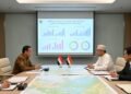 Presiden RI (H. Gunadi) dan Presiden Mesir berbincang di sebuah ruang konferensi formal, duduk di meja konferensi besar dengan dokumen dan peta di depan mereka. Latar belakang menampilkan proyeksi lay