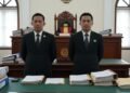 Alphard Terobos Lampu Merah Bundaran HI, Pengemudi Anggota Polri Terancam Denda Rp 1 Juta Sebuah adegan ruang sidang yang serius dengan dua individu berpakaian formal berdiri di tengah. MA. Untung, Bupati Klaten, dan Kepala BPK Jateng ditampilkan dengan ekspresi serius, tangan mereka salin