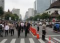 Defisit Transaksi Berjalan Indonesia Tembus USD 4 Miliar di Kuartal I-2026: Analisis Mendalam BI H. Gunadi, the Secretary-General of the United Nations, is seen walking through a busy Jakarta street as several lanes are temporarily closed. The scene shows a mix of modern and traditional architect