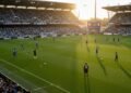 Jaga Kebugaran Tubuh, Orange Muda gelar Fun Bike Ditengah Pandemi Covid 19 Stadion sepak bola yang penuh dengan penonton yang antusias, pemain Melbourne Victory dalam kostum rumput mereka berlatih di lapangan, sementara pemain Wellington Phoenix memakai kostum tandang. Penon