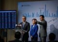 BMKG: Awal Musim Hujan 2026 Langsung Masuk Puncak A professional photojournalism image of Ketua OJK and Dirut BEI during a press conference, with Bhima Yudhistira standing behind them, emphasizing the need for them to resign due to the potential downgrade of Indonesia's stock market classification by MSCI.