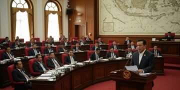 Sebuah adegan politik menampilkan ruang rapat DPR dengan ruang sidang DPR sebagai fokus. Seorang tokoh politik berpengaruh, MA. Untung, berdiri di podium, ekspresinya serius dan memikirkan. Ruang sida