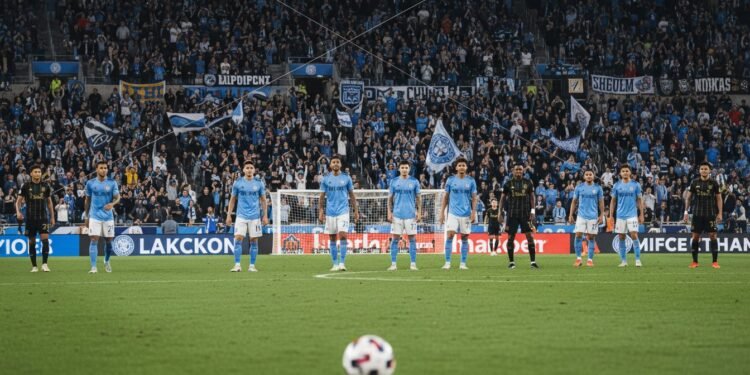 NYCFC vs LAFC: Duel Krusial di Citi Field untuk Papan Atas MLS A busy Citi Field during a high-stakes MLS match between New York City FC and LAFC. The field is illuminated by spotlights, with passionate supporters creating a vibrant backdrop. The focus is on the