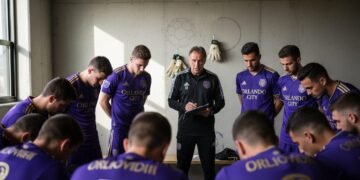 Orlando City players in a locker room, huddling around their coach, showing determination before a match against D.C. United.