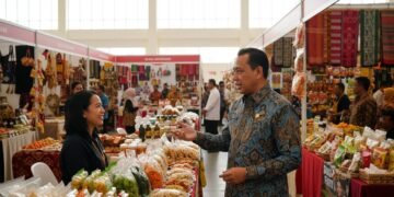 Gubernur Andi Sudirman berbincang dengan pedagang di Sulsel Expo 2026, menunjukkan komitmennya dalam mendukung UMKM lokal. Latar belakang penuh dengan stall-stall menarik yang menampilkan berbagai pro