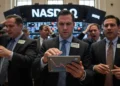 Tips Ampuh Mengatasi Ponsel Android Cepat Panas Suasana bursa saham yang ramai dengan trader berpakaian seragam, sibuk memeriksa layar komputer mereka. Tanda Nasdaq di belakang tampak jelas, dengan lampu-lampu yang berkedip-kedip. Atmosfernya menun