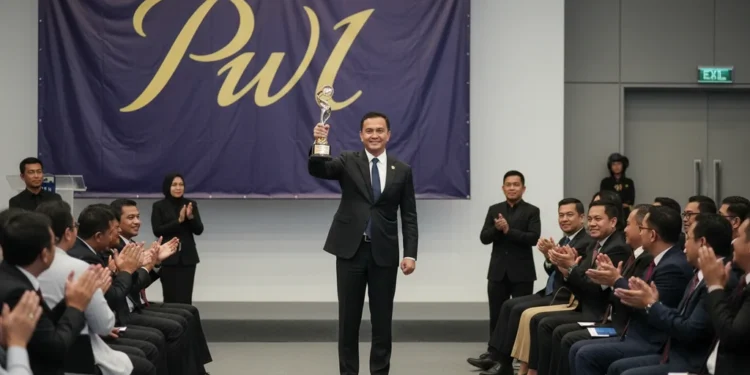Andi Sudirman Terima Penghargaan dari PWI Sulsel Andi Sudirman menerima penghargaan dari PWI Sulsel. Dia berdiri dengan percaya diri di atas panggung dengan trofi di tangan. Penonton duduk dalam barisan dengan tatapan penuh penghargaan. Penerangan y