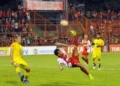 Makassar Dorong Digitalisasi Bansos: Langkah Strategis Wali Kota Appi untuk Penyaluran Tepat Sasaran Rizky Eka, the best player of the match between PSIM Jogja and PSM Makassar, stands confidently on the pitch. The background shows a stadium with cheering fans. The setting sun creates a warm glow, an
