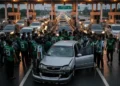 Ekonom Kritik Pemindahan Gaji PNS ke Koperasi Desa Merah Putih Sebuah adegan yang menunjukkan momen tegang di sebuah plazas jalan tol. Sebuah grup besar orang, yang kemungkinan adalah penggemar PSS Sleman, berkumpul di sekitar sebuah kendaraan yang rusak. Bagian
