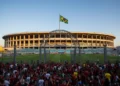 The iconic Maracanã Stadium in Rio de Janeiro, with its grand entrance gates and the Brazilian flag, bathed in warm afternoon sunlight, preparing for the matchday 31 between Fluminense and Santos.