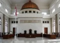 Pemerintah Dituding Abaikan HAM dalam Penanganan KDRT The image shows the grand Supreme Court building in Indonesia, symbolizing the authority and solemnity of the legal system. The urgent need for reform in the military judiciary is highlighted through