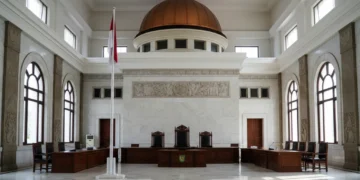 The image shows the grand Supreme Court building in Indonesia, symbolizing the authority and solemnity of the legal system. The urgent need for reform in the military judiciary is highlighted through