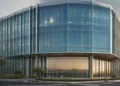 Gempa Magnitudo 2,8 Melanda Bone SULSEL tadi Siang, Menyusul 5,2 di Tutuyan SULUT BMKG headquarters in Jakarta with a large digital screen displaying weather data. The building has sleek glass facades and a prominent signboard at the entrance. The background shows a clear sky with