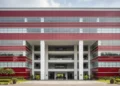 The image shows the grand entrance of the KPK headquarters, symbolizing the institution's role in combating corruption. The modern architecture and natural lighting highlight the transparency and prof