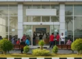 BTS Pecahkan Rekor: Konser Comeback di Gwanghwamun Square, Situs Warisan Budaya Korea The image shows the entrance of the Makassar Fisheries Office with a signboard reading 'Dinas Perikanan Makassar'. Inside, fisherman and their families are seen discussing the recent increase in fuel