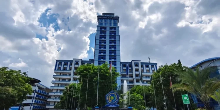 Unismuh Makassar Wisuda Hari Kedua, 192 Lulusan RPL Terkuhak Unismuh Makassar's grand entrance is shown with graduates in formal attire, holding their diplomas, celebrating the second graduation day. The building features a sleek glass facade and a prominent en
