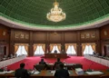 Joget dan Lelucon Presiden Jadi Sorotan Publik The interior of the DPR Commission X meeting hall in Jakarta, with a grand ceiling, dark wood panels, and a formal atmosphere where commissioners are discussing the policy of not increasing student cl