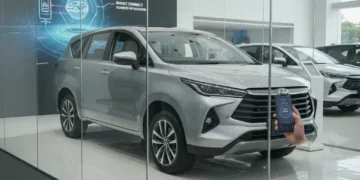 A modern car dealership showroom displaying the latest Toyota Kijang Innova Zenix, with a smartphone being used to activate the vehicle's ignition, highlighting the car's advanced technology and user-