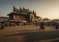 Istana Kadipaten di Makassar dengan latar belakang pasar tradisional dan kehidupan sehari-hari yang ramai, mencerminkan konflik yang menegang di kota.