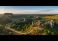 A panoramic view of the Maros-Pangkep Geopark in Sulawesi Selatan, featuring lush green landscapes, towering cliffs, and ancient rock formations. The scene highlights the natural beauty and historical