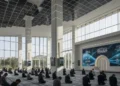 A modern mosque with advanced technology, symbolizing the transformation of Muslim communities in embracing modernity and progress. The mosque features a sleek design with large glass windows, a minim