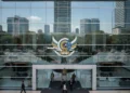 The Ministry of Law and Human Rights building in Jakarta, with its glass facade and emblem, symbolizing the institution's role in human rights. The interior is bright and open, reflecting the professi