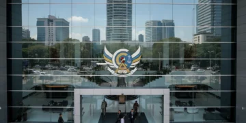 The Ministry of Law and Human Rights building in Jakarta, with its glass facade and emblem, symbolizing the institution's role in human rights. The interior is bright and open, reflecting the professi