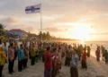 HKSN 2024 Makassar: Perkuat Solidaritas untuk Indonesia Emas A large crowd of KAHMI alumni and HMI members celebrating the 60th anniversary of KAHMI at Pantai Bosowa in Makassar. The scene features the KAHMI flag and the setting sun, with traditional Indonesian
