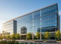 Pembaruan AI BRI: Sabrina hingga WISE untuk Layanan Lebih Inklusif A modern Microsoft building with a large glass facade and a prominent logo, set against a clear sky with bright sunlight. The surroundings include greenery and urban elements, reflecting a professiona