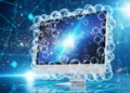Hyundai Stargazer X Kemewahan dan Teknologi Canggih yang Terjangkau Foto makro tiga baterai ponsel yang berbeda diletakkan di atas meja kayu bersih bersanding dengan port daya laptop terbuka beserta kabelnya. Cahaya matahari pagi lembut menembus tirai menciptakan sina
