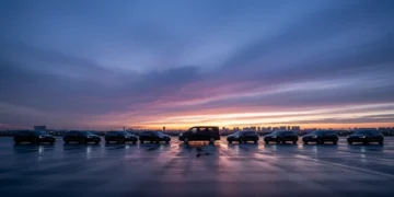 Mobil listrik berwarna gelap terparkir rapi di malam hari dengan latar langit ungu dan cahaya kota yang lembut.