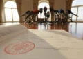 Deklarasi Kabupaten Enrekang menjadi Kabupaten Literasi di Sulsel Foto dokument resmi terbuka dengan segel merah dan teks anggaran di latar depan mikrofon rapat kantor.