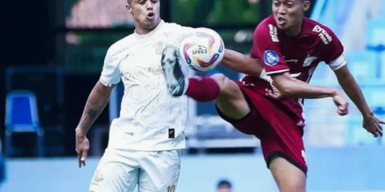 Susunan Pemain PSM Makassar vs Madura United: Lars Veldwijk Starter Suasana pertandingan sepak bola malam hari dengan papan strategi taktik kayu bercahaya di bawah sorot lampu stadion yang dramatis dan latar belakang buram dari lapangan rumput basah.